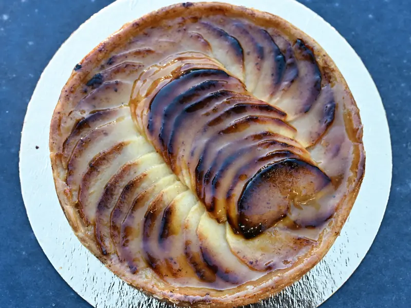 Une tarte aux pommes maison, ses tranches dorées en rosace