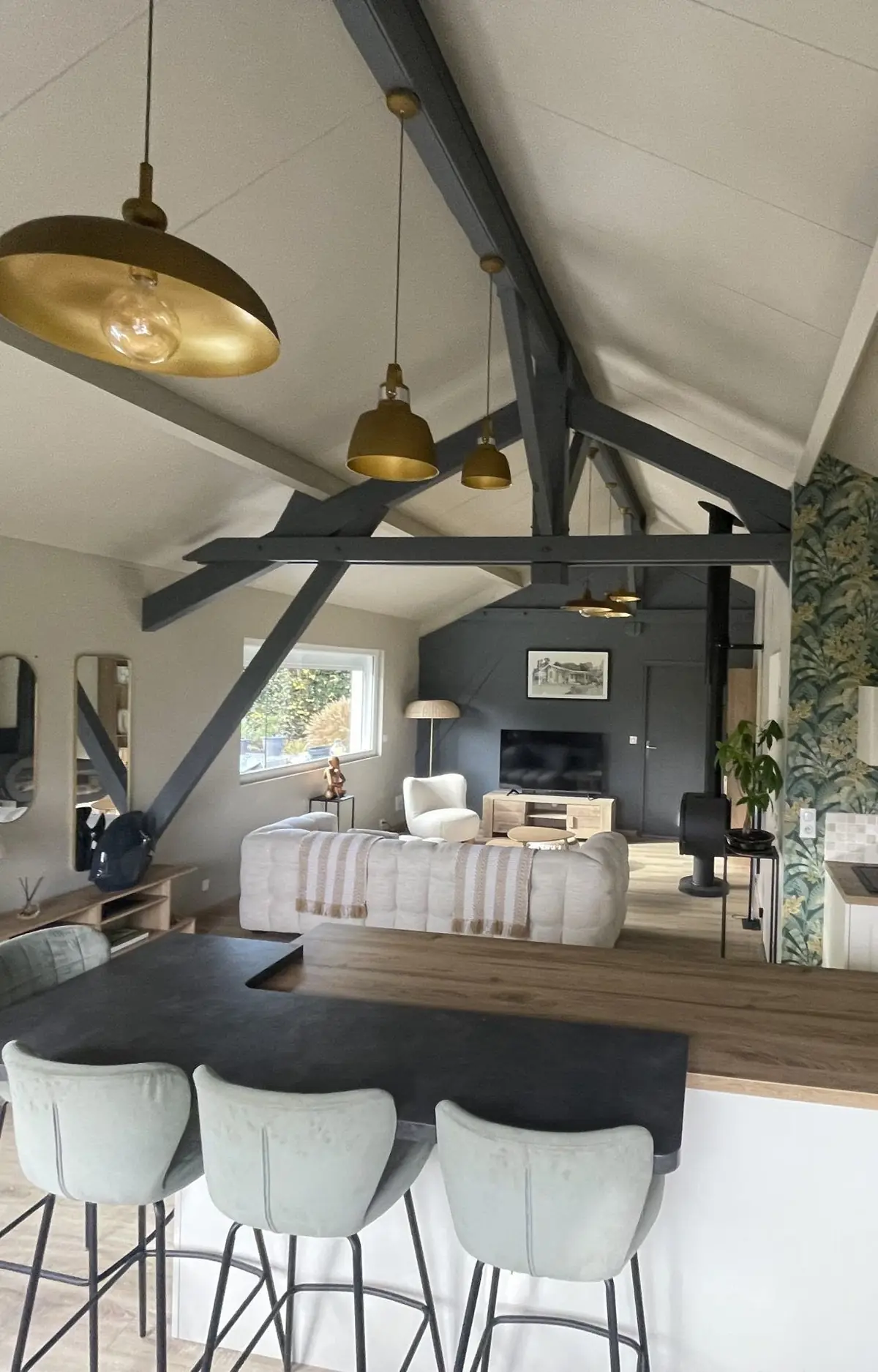 La pièce à vivre du Chalet Normand, sous sa charpente peinte en gris