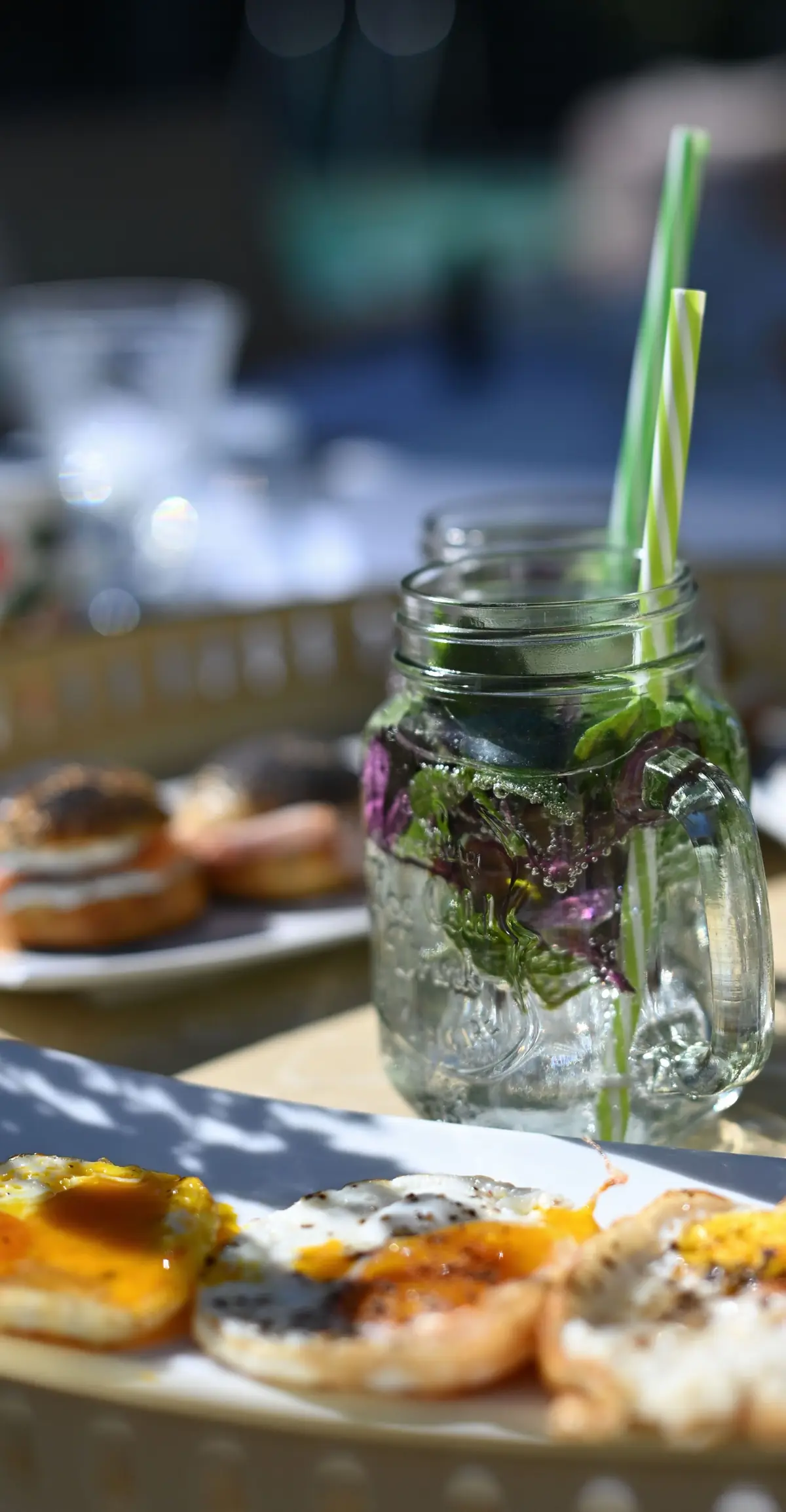 Des œufs au plat et un verre d’eau aux herbes, servis dehors au soleil