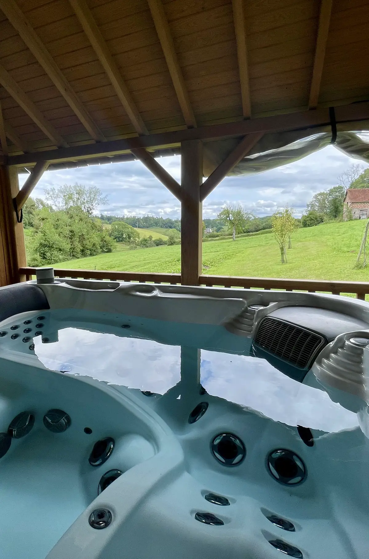 The Hameau’s outdoor hot tub under its gazebo, looking out over the meadows and the valley