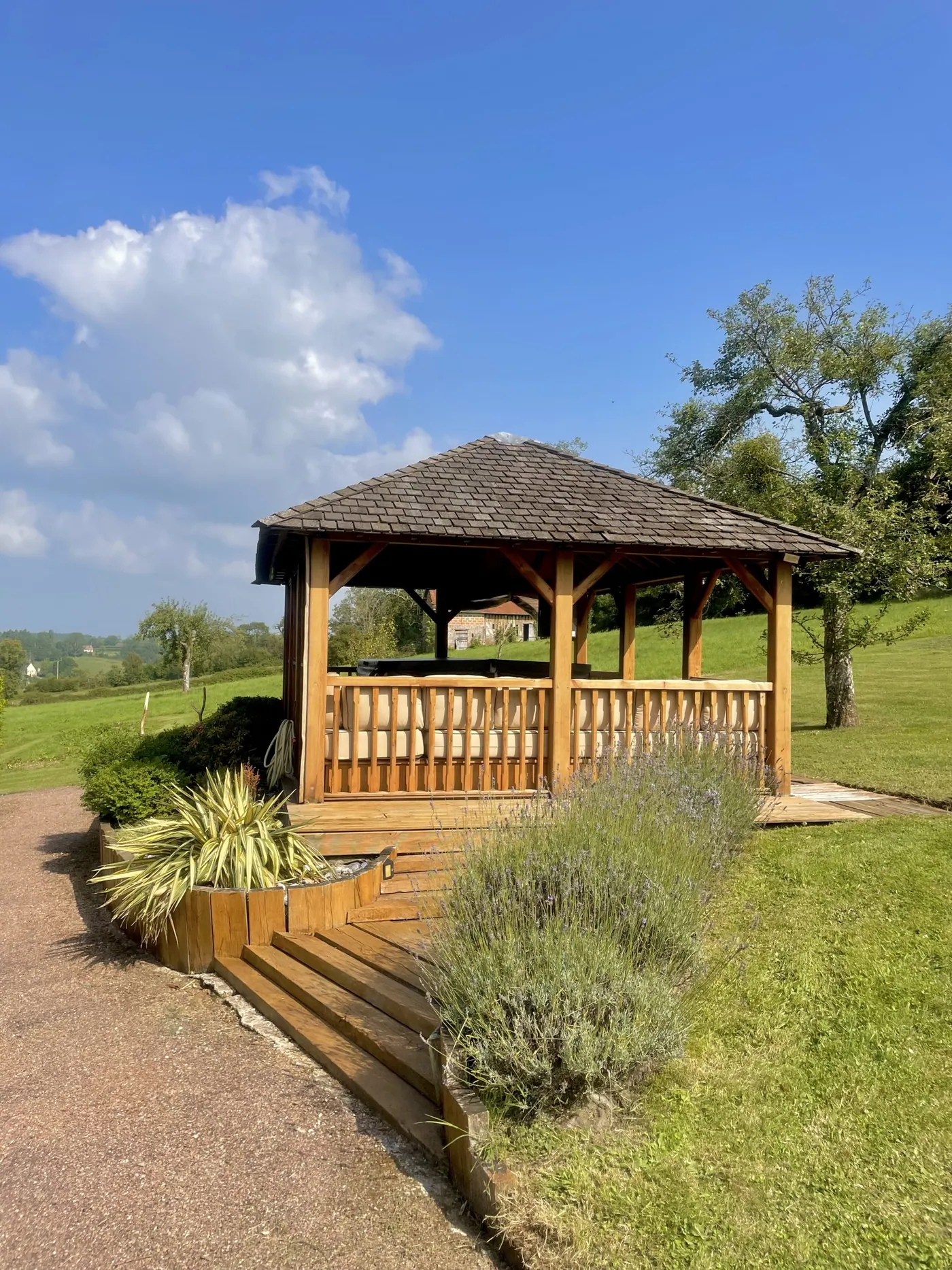 Le kiosque du jacuzzi en été, la lavande au pied de ses marches de bois
